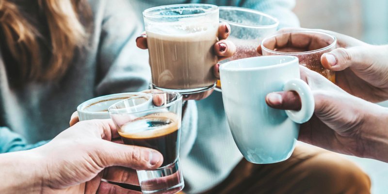 Mehrere Personen stoßen mit verschiedenen Kaffeetassen und Bechern an.. Artikel "Kaffee: Gesundheit und Umwelt" öffnen.