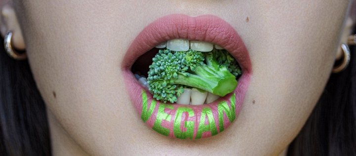 geöffnete Lippen mit Brokkoli und der Aufschrift "vegan"