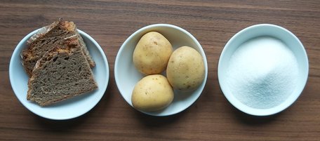 Kleine Teller mit Brot, Kartoffeln und Zucker