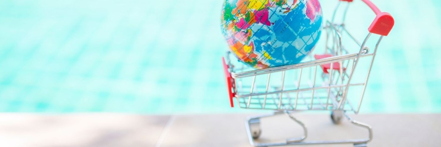 Vor einem Schwimmbecken steht ein Einkaufswagen in dem eine Weltkugel liegt.