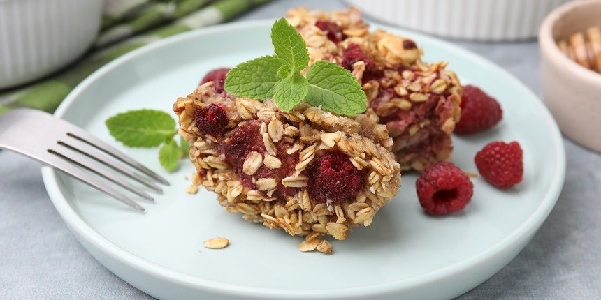 Auf einem weißen Teller liegt ein gebackene Haferflocken mit Himbeeren. . Artikel "Stressfrei frühstücken" öffnen.