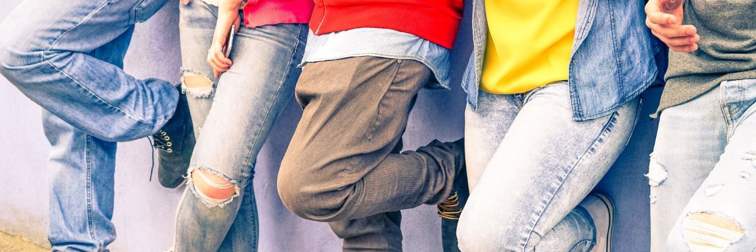 Fünf Jugendliche stehen angelehnt vor einer Wand. 