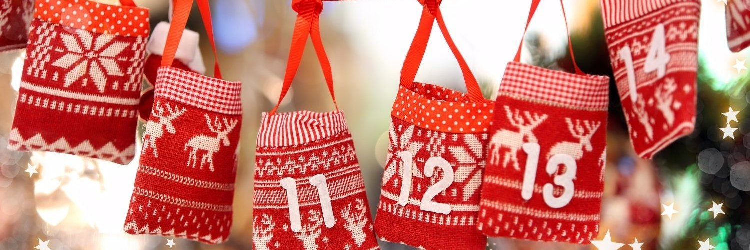 Rote kleine Säckchen mit Zahlen und weihnachtlichen Motiven hängen an einer Schnur. 