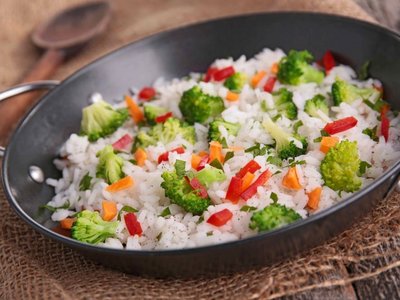 Es ist eine Mahlzeit mit gekochtem Reis, Brokkoli und Paprika abgebildet.