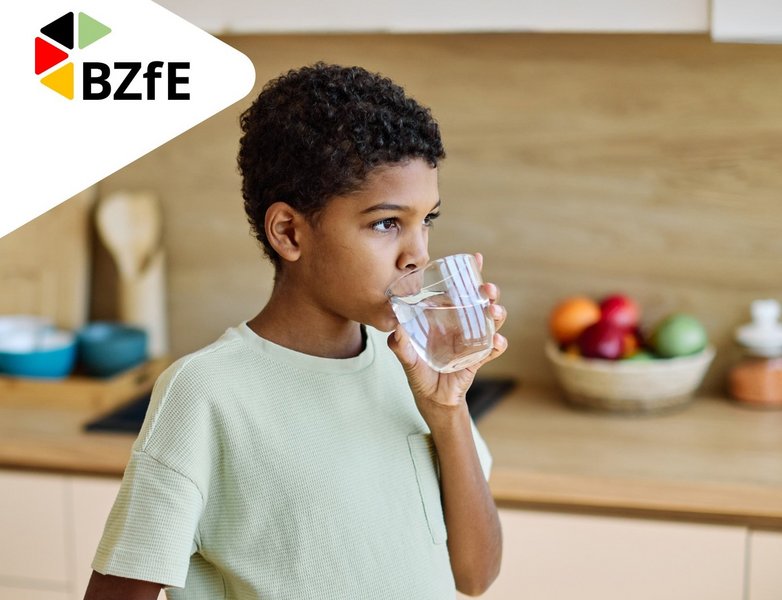 Ein Junge trinkt ein Glas Wasser.