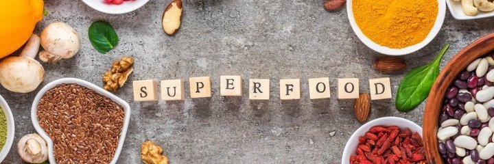 "Superfood" in der Mitte mit beschrifteten Würfeln gelegt, daneben verschiedene Schalen mit "Superfoods"