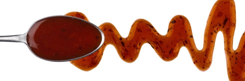 Teriyaki Soße auf einem Löffel, davor eine Spur der Soße 