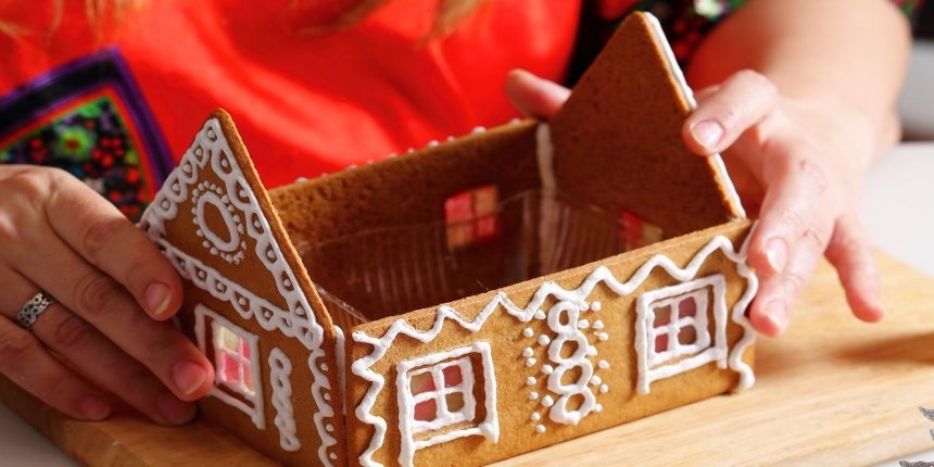 Eine Frau baut ein Lebekuchenhaus zusammen.. Artikel "Lebkuchenhaus selbst gemacht" öffnen.