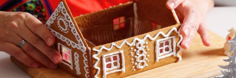 Eine Frau baut ein Lebekuchenhaus zusammen.