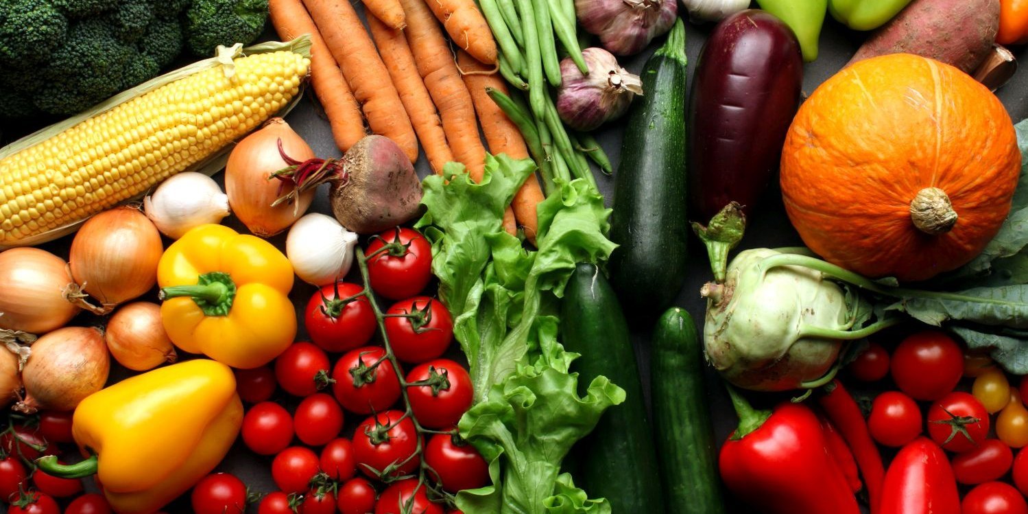 Verschiedene pflanzliche Lebensmittel wie Möhren, Tomaten, Paprika und Mais liegen auf einem Tisch.. Artikel "Lebensmittelverschwendung – darum betrifft es uns" öffnen.