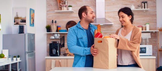 Mann und Frau in Küche mit voller Einkaufstasche