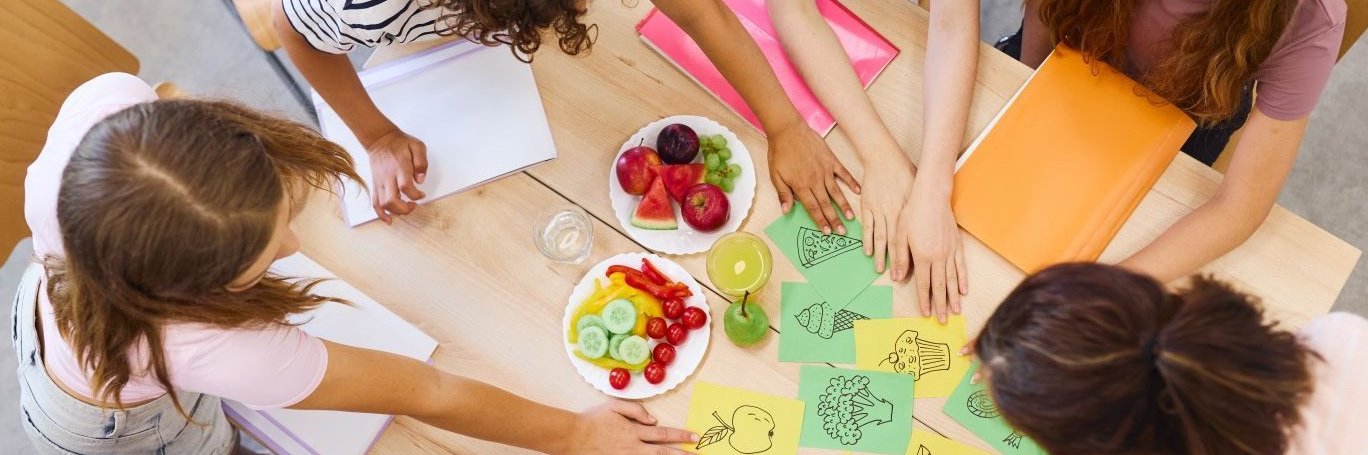 Schüler ordnen Lebensmittelkarten am Tisch.