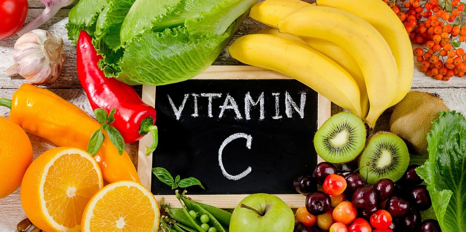 Eine Kreidetafel mit der Aufschrift Vitamin C auf einem Haufen Gemüse und Obst.. Artikel "Nahrungsergänzungsmittel" öffnen.