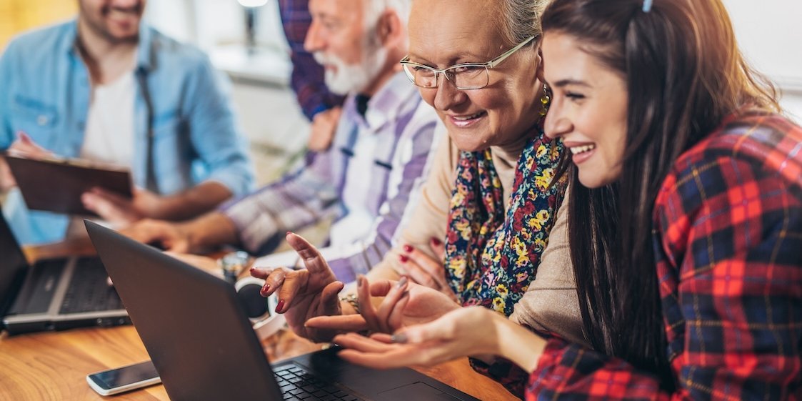 Eine altersgemischte Lerngruppe Erwachsener arbeitet an Laptops.. Artikel "Buchstäblich fit" öffnen.