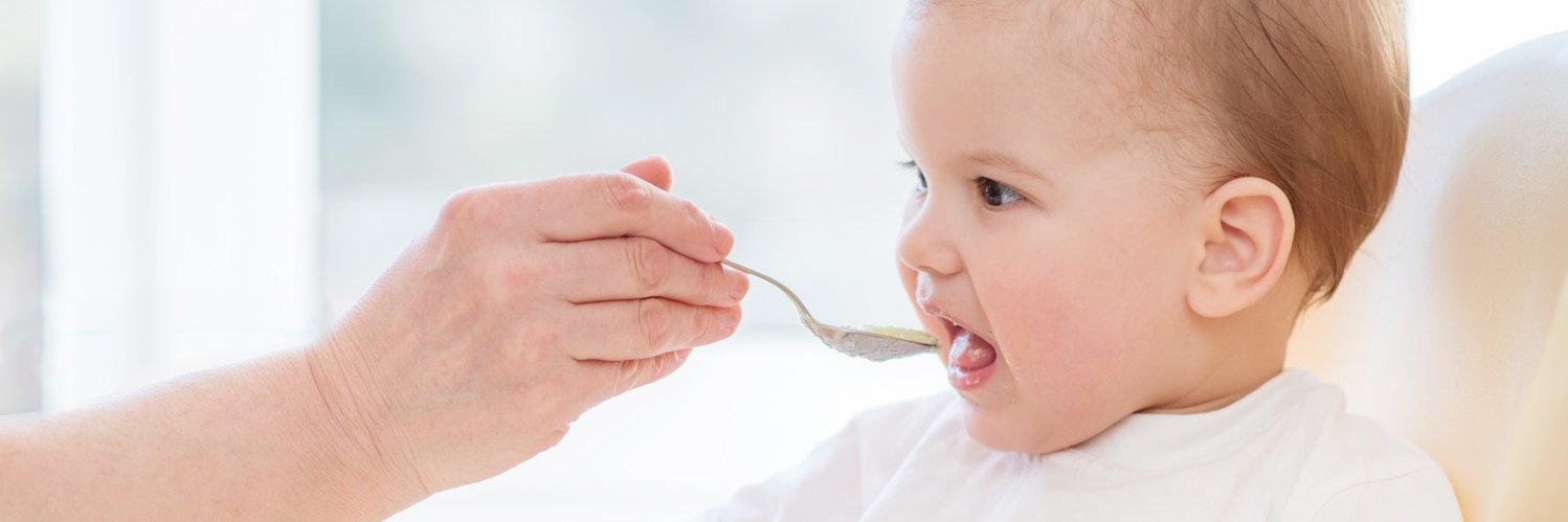 in Baby wird mit einem Löffel gefüttert. 