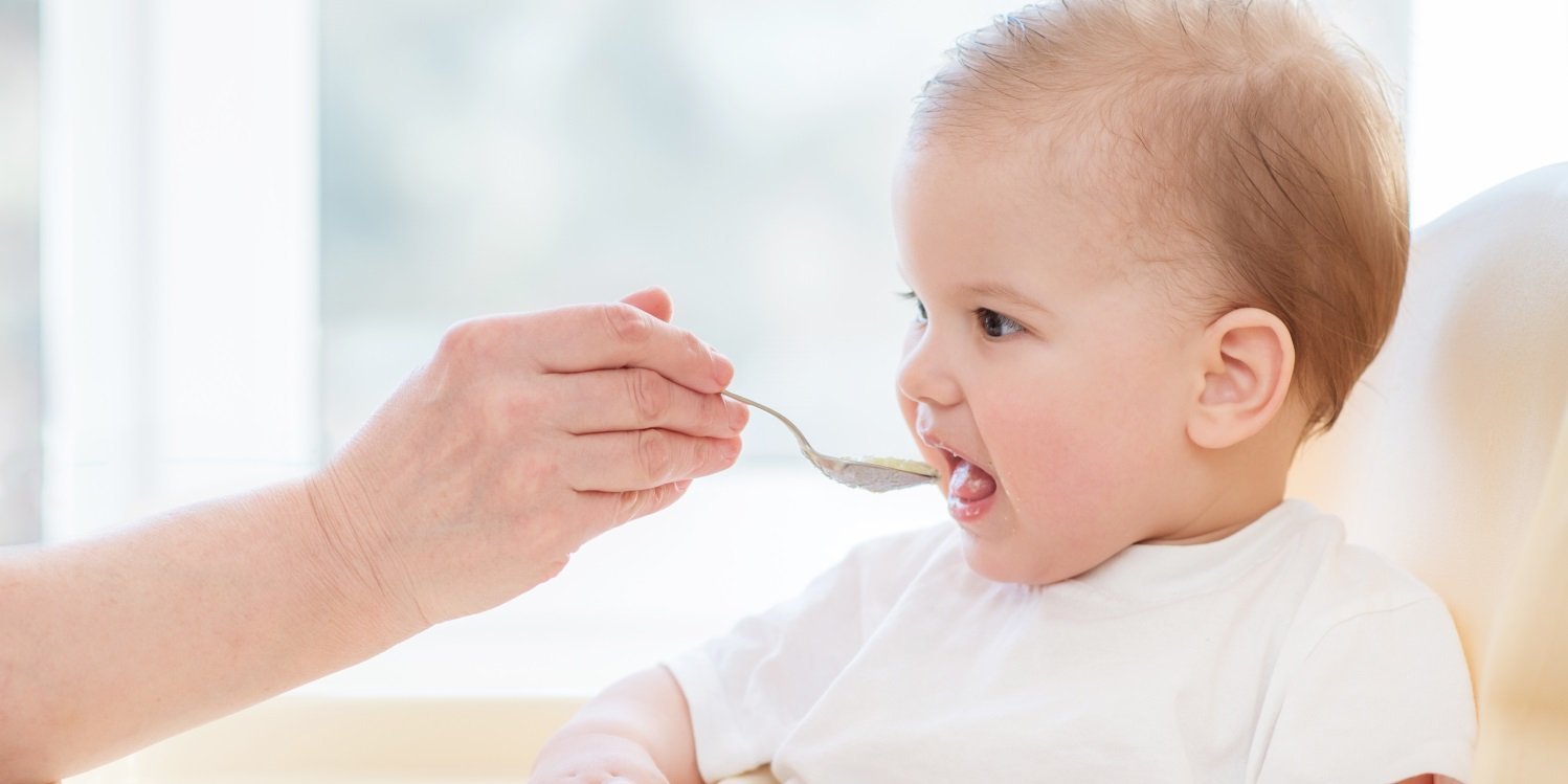 in Baby wird mit einem Löffel gefüttert. . Artikel "Babybrei aus dem Gläschen" öffnen.