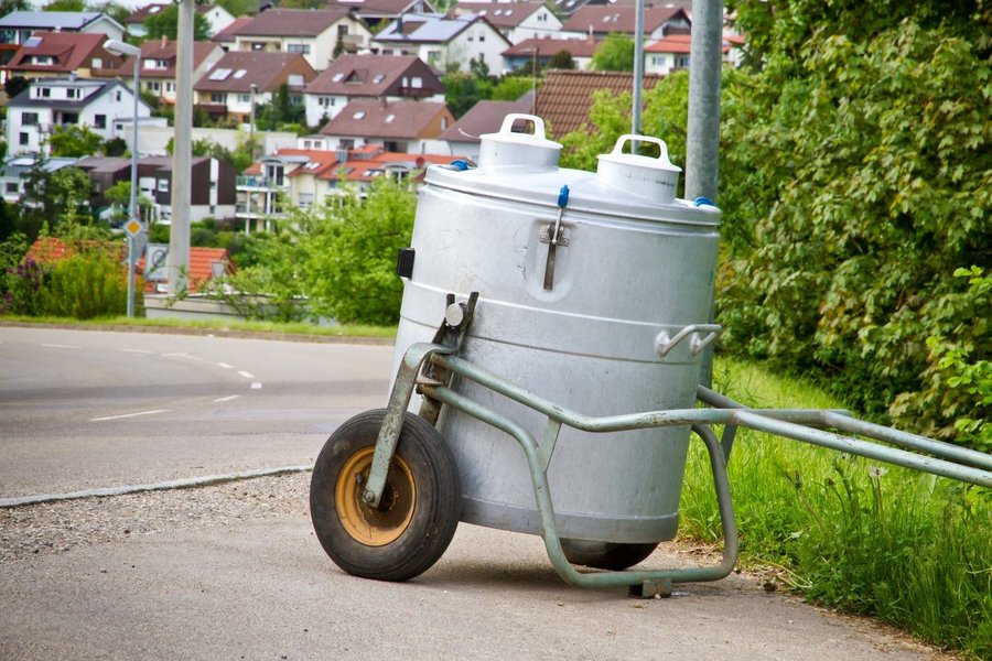 Ein Milchwagen steht an einem Straßenrand.