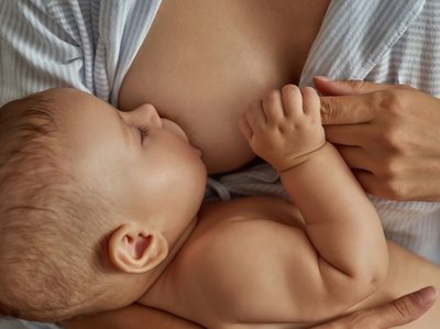 Ein Baby wird an der Brust gestillt.