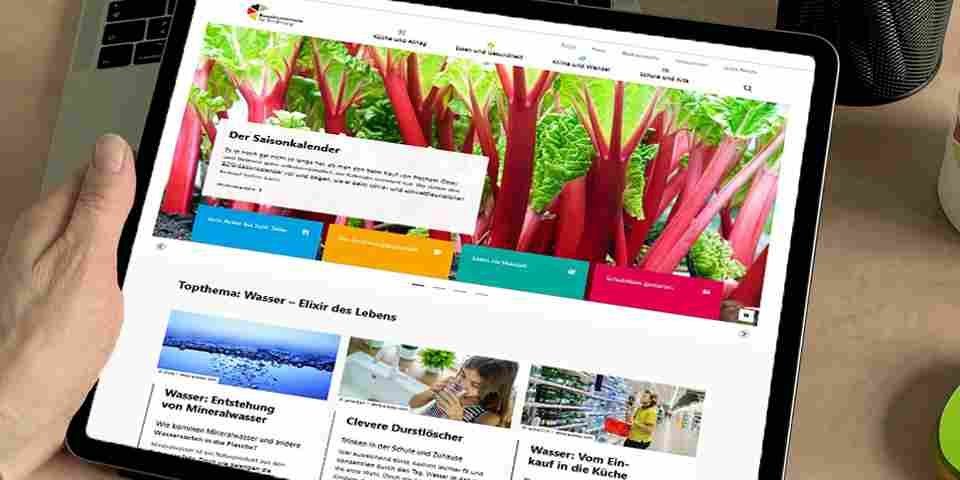 Eine Hand hält ein Tablet auf dem die neue Startseite des Bundeszentrums für Ernährung aufgerufen ist, mit einem Bild von Rhabarber und verschiedenen Kategorien.. Artikel "Neue Website des BZfE" öffnen.