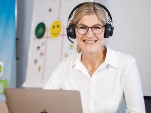 Amely Brückner sitzt mit Kopfhörer vor Laptop.