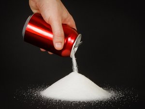 Aus einer Energy-Dose wird Zucker geschüttet, um die große Menge Zucker in dem Getränk zu verdeutlichen.