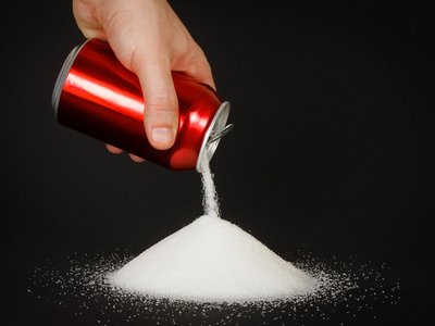 Aus einer Energy-Dose wird Zucker geschüttet, um die große Menge Zucker in dem Getränk zu verdeutlichen.