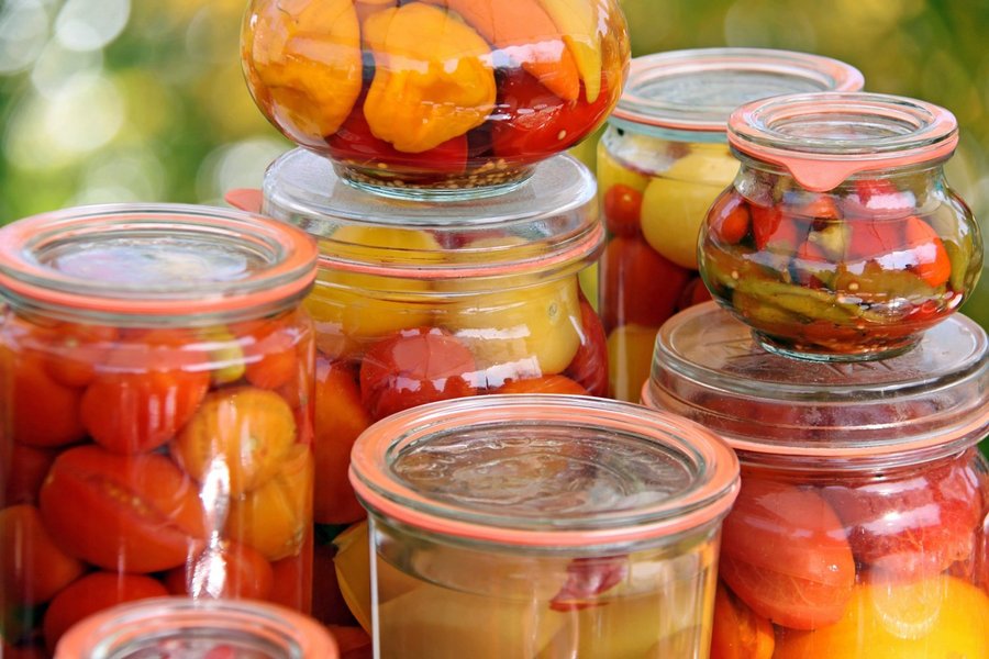 Gläser mit eingekochten Tomaten und Paprika.