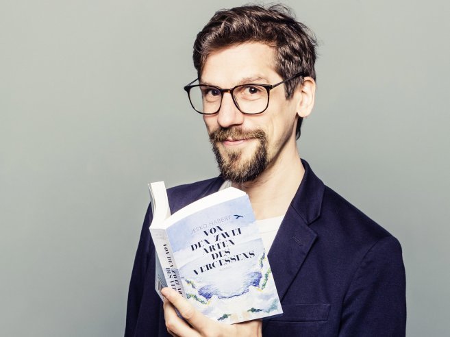 Jesko Habert hält ein Buch in der Hand.
