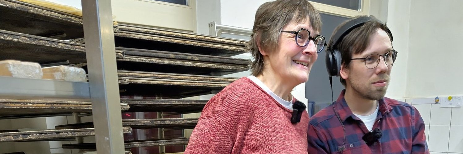 Eine Frau und ein Mann stehen vor Regalen.