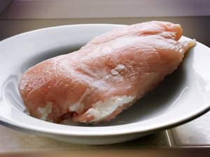 Ein Stück rohes Fleisch liegt auf einem Teller.