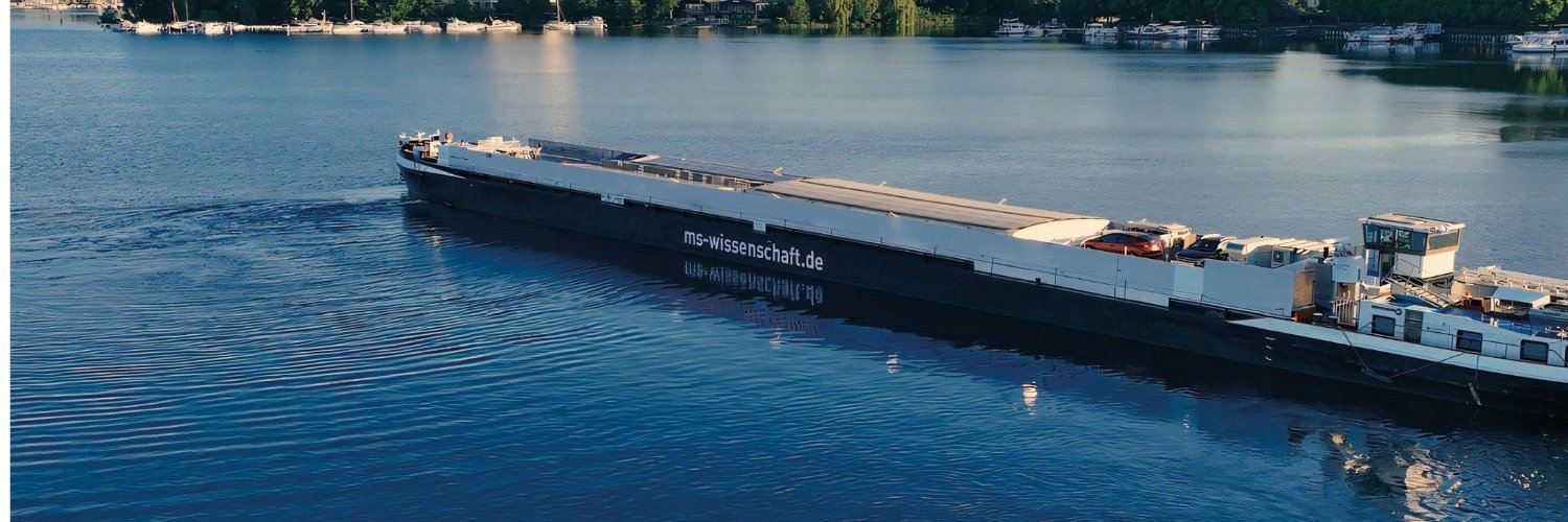 Das Ausstellungsschiff MS Wissenschaft fährt auf einem Fluss.