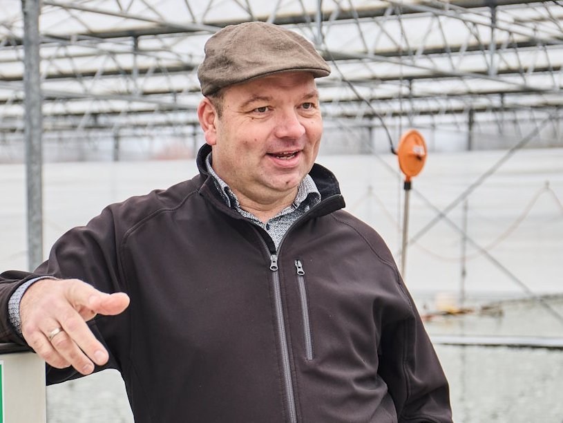 Ein Mann steht in einem Algengewaechshaus.