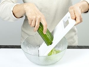 eine Person reibt eine Salatgurke.