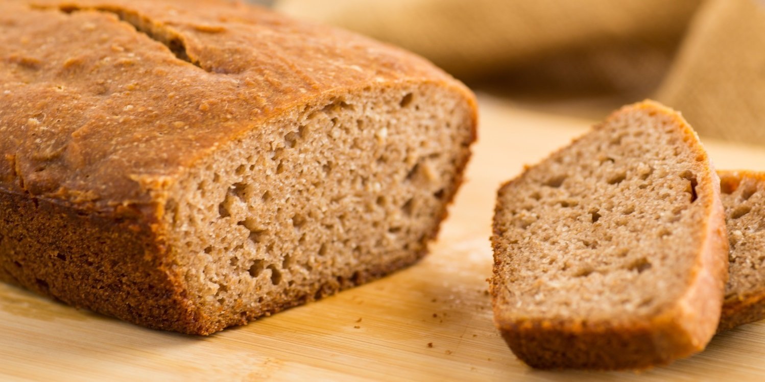 Auf einem hellen Holzbrett liegt ein aufgeschnittenes Vollkornbrot.. Artikel "Was machen eigentlich Natron, Backpulver, Hirschhornsalz und Co.?" öffnen.
