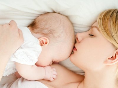 Mutter und Baby schlafen Kopf an Kopf. 