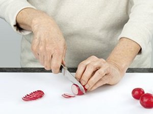 eine Person schneidet die Radieschen.