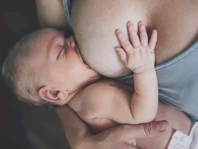 Ein Baby wird an der Brust gestillt.