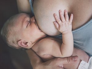Ein Baby wird an der Brust gestillt.