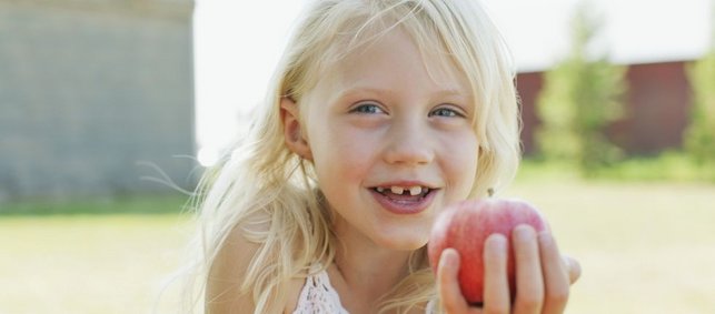 Mädchen hält roten Apfel in der Hand