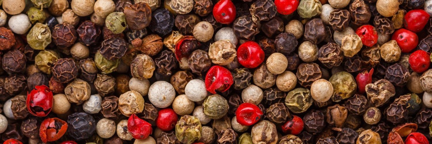Die Bildfläche ist komplett ausgefüllt mit Pfefferkörnern in verschiedenen schwarzen, weißen, und roten Farbnuancen.