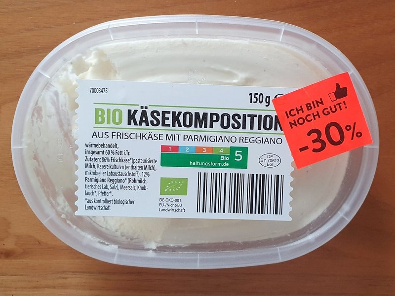 Auf einem Behälter mit Frischkäse klebt ein Aufkleber mit dem Text "Ich bin noch gut, minus 30 Prozent".