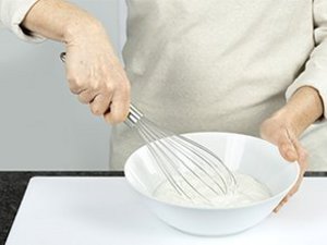 eine Person verrührt Quark in Schüssel.