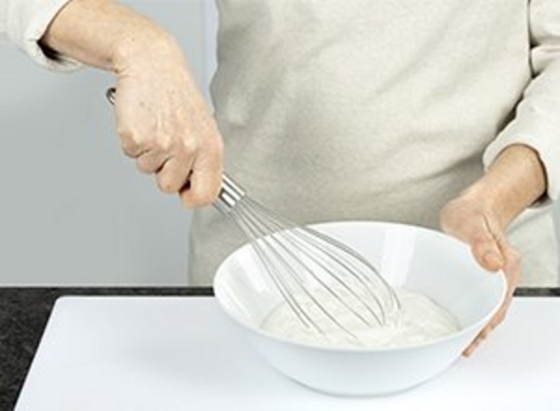 eine Person verrührt Quark in Schüssel.