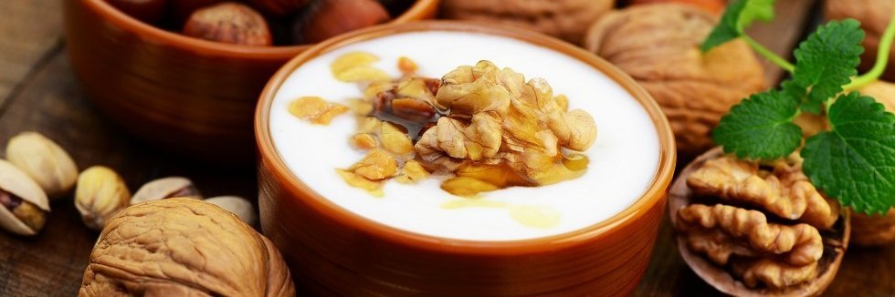 Eine Schale Joghurt mit gehakten Walnüssen.