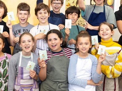 Mädchen und Jungen einer Grundschulklasse halten stolz den Ernährungsführerschein in der Hand. 