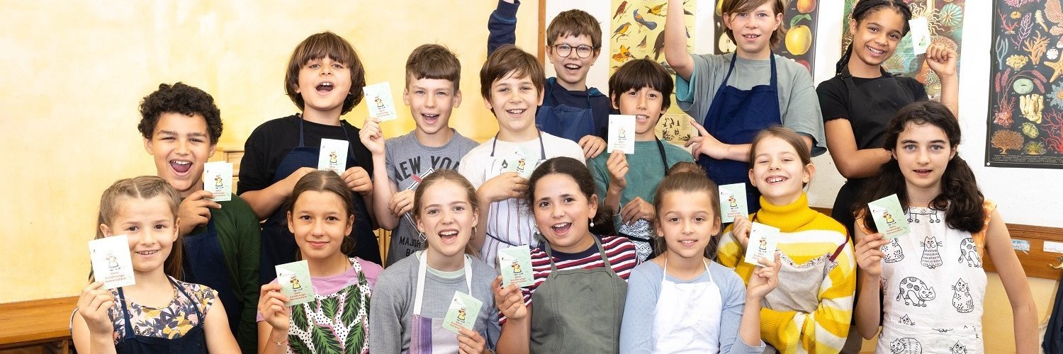 Mädchen und Jungen einer Grundschulklasse halten stolz den Ernährungsführerschein in der Hand. 