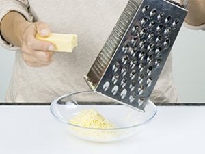 Eine Person reibt Käse.