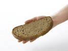 Eine Schreibe Brot liegt auf einer Erwachsenenhand.