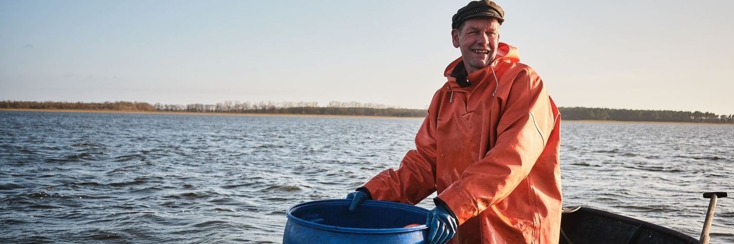 Ein Fischer seht auf einem Ruderboot.
