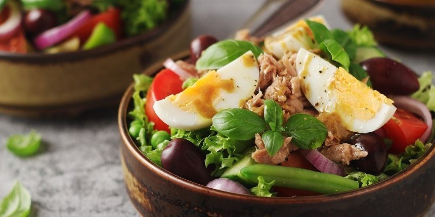 Eine Schale Salat mit grünem Salat, Tomaten, grüne Bohnen, Oliven, Zwiebeln, Thunfisch und hartgekochtem Ei. . Artikel "Eier-Reste vom Feste" öffnen.